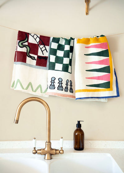 Set of 3 games-inspired games tea towels hanging above a sink by Amuse La Bouche