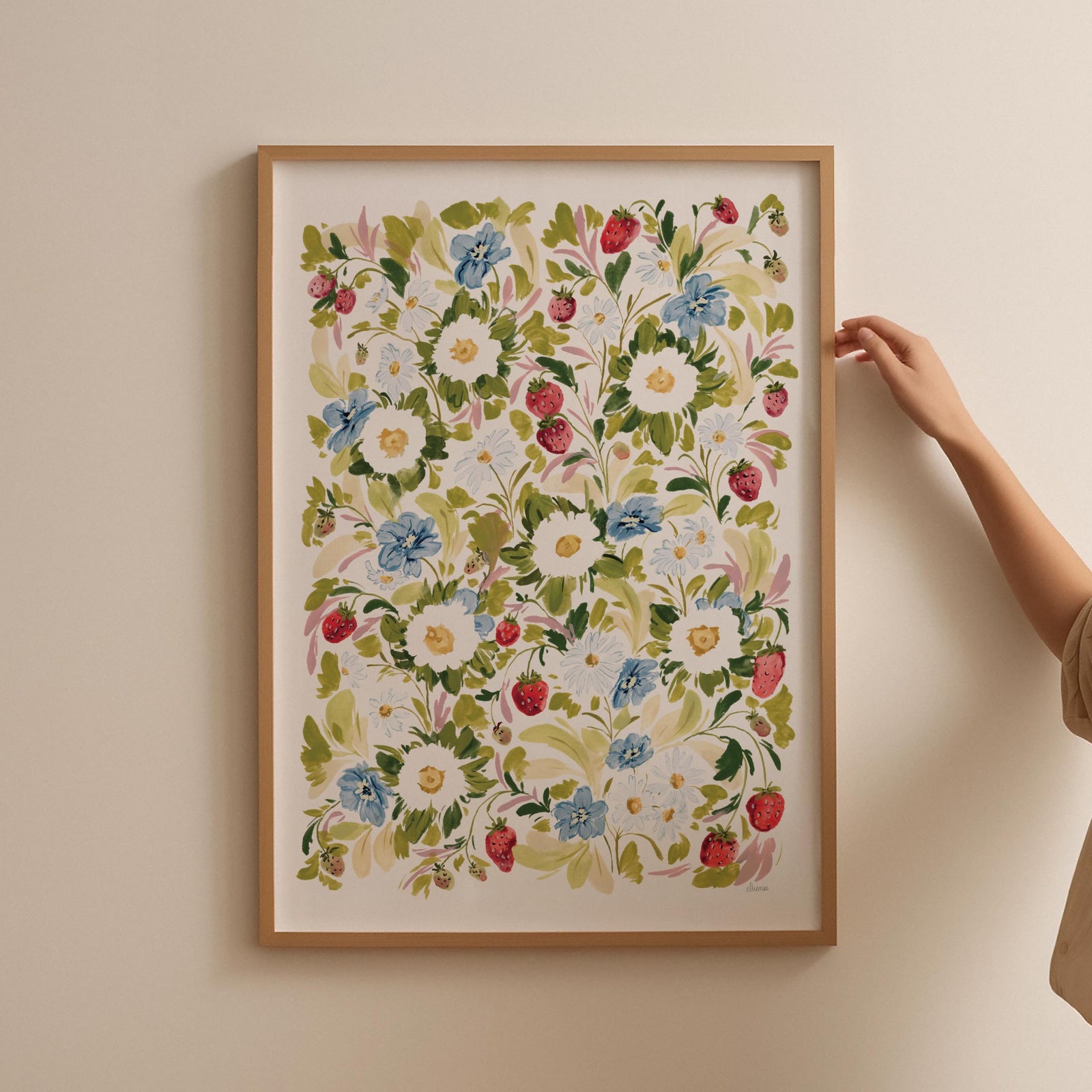 Garden strawberries print framed in thin oak frame against blank wall.