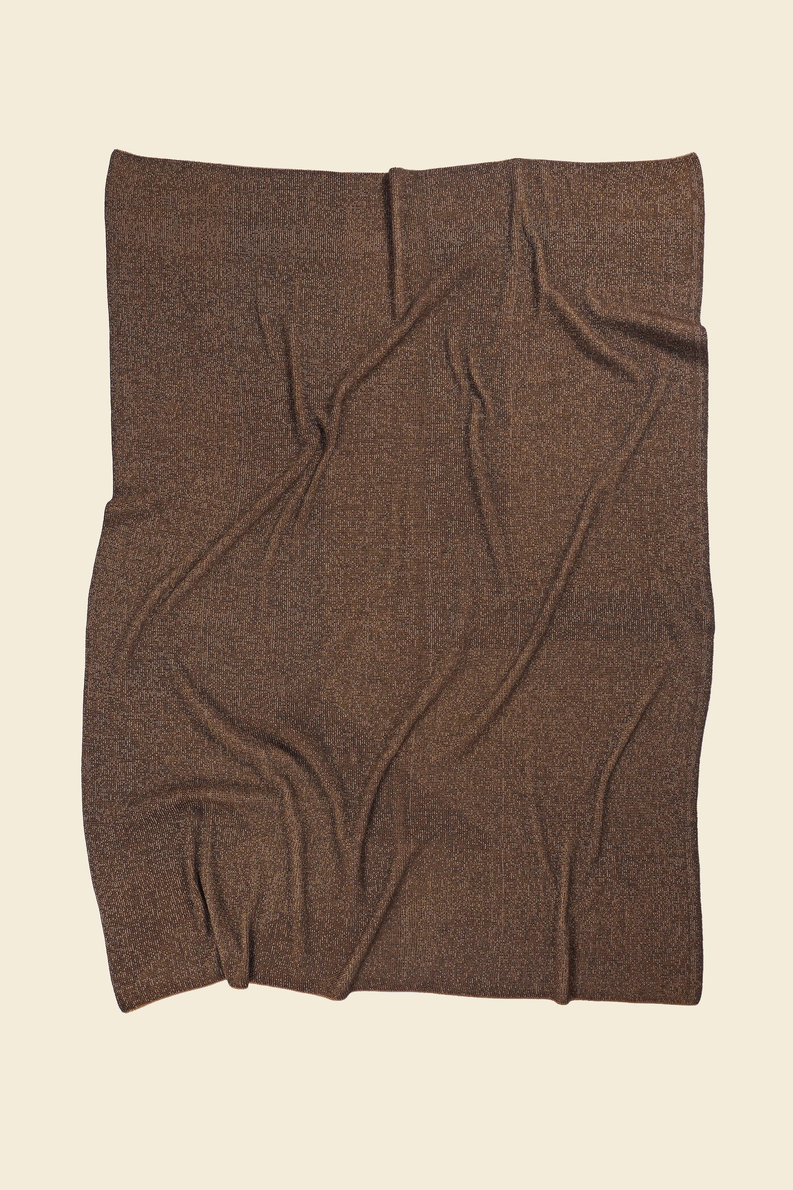 back side of brown/gold geometric ikat knit blanket in merino wool and organic cotton