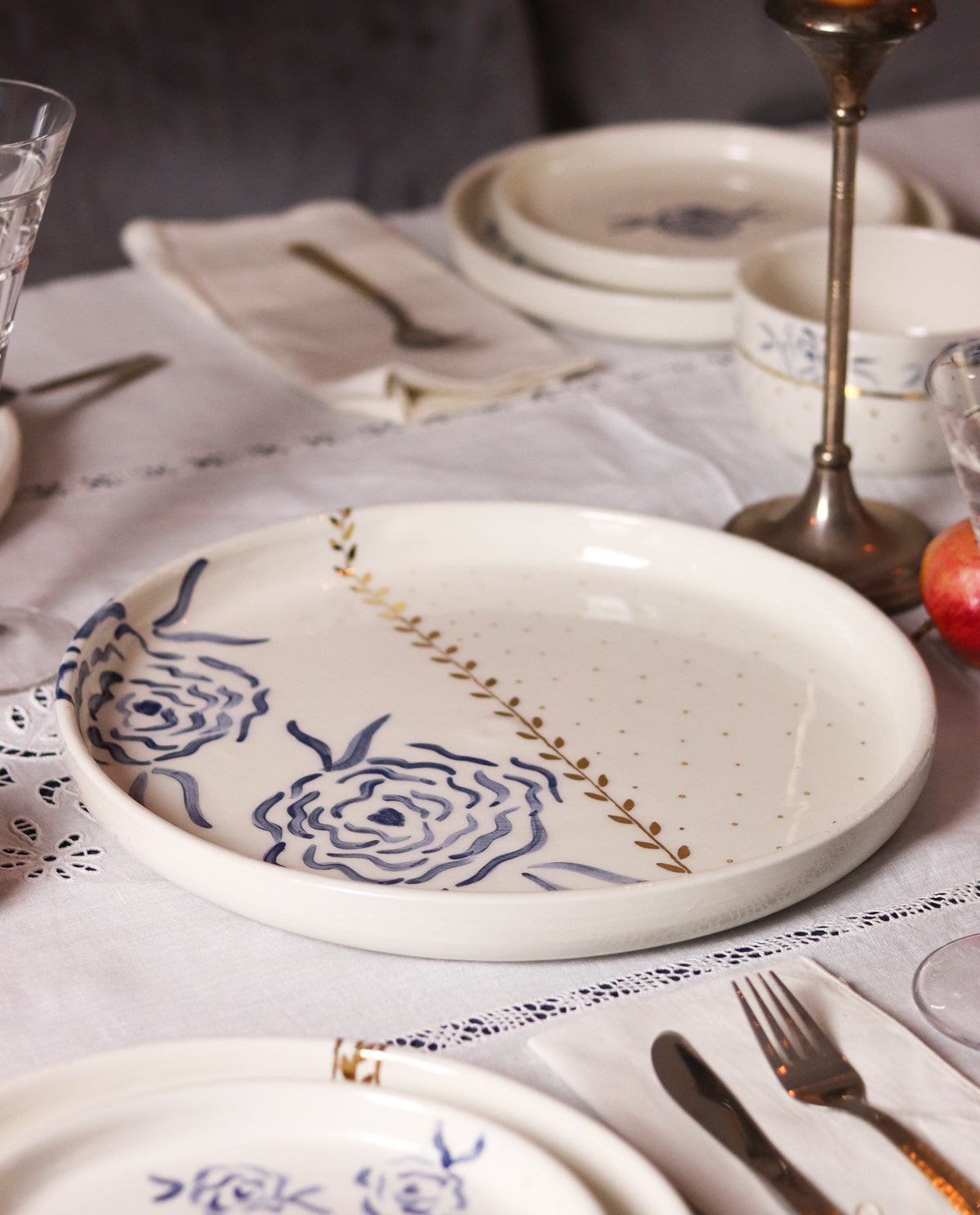Ceramic plates with floral designs on a table setting with cutlery and glasses.