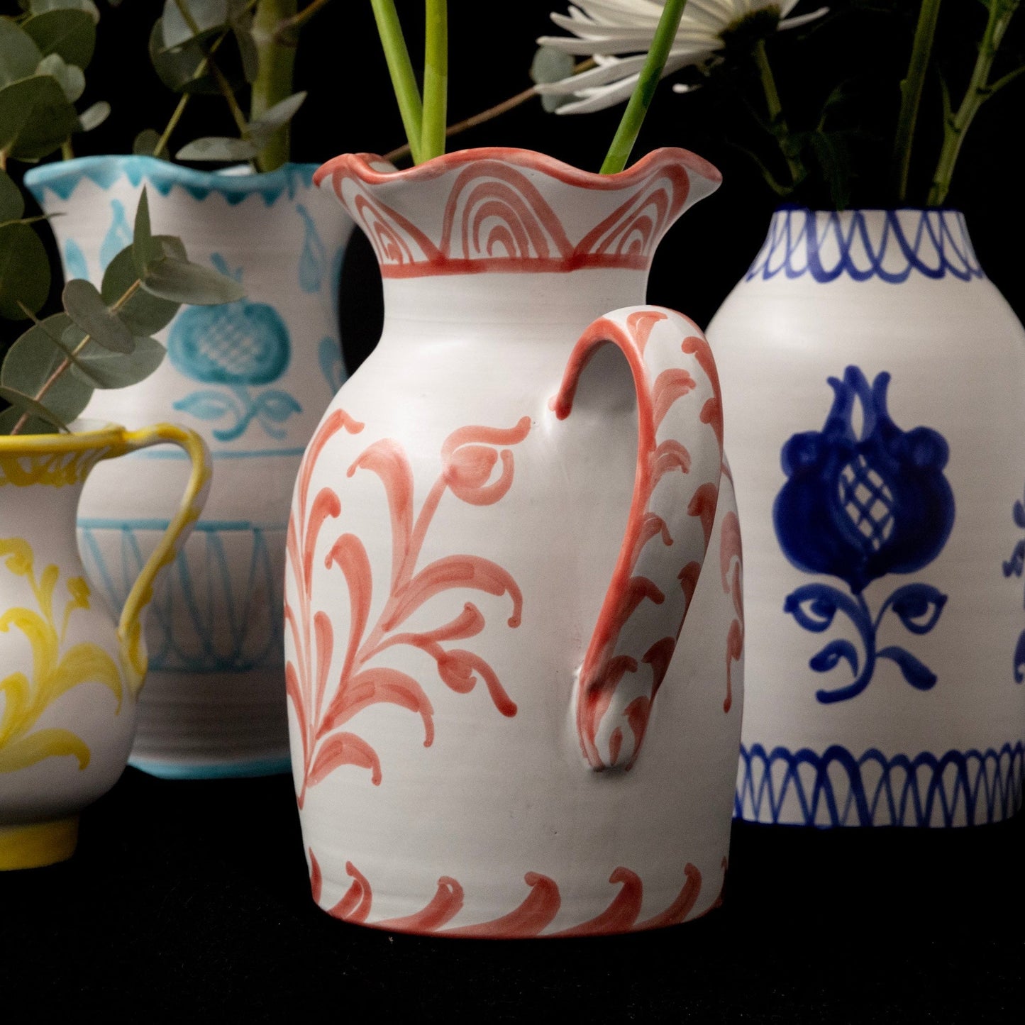 Four decorative vases with floral patterns on a black background - lifestyle
