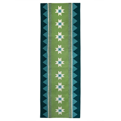 Green runner rug handwoven from New Zealand wool with a geometric design of star motifs and a zig zag border inspired by Victorian tiles. 
