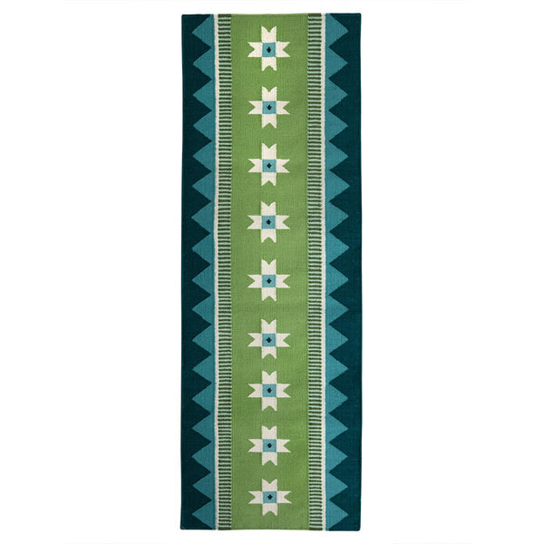 Green runner rug handwoven from New Zealand wool with a geometric design of star motifs and a zig zag border inspired by Victorian tiles. 
