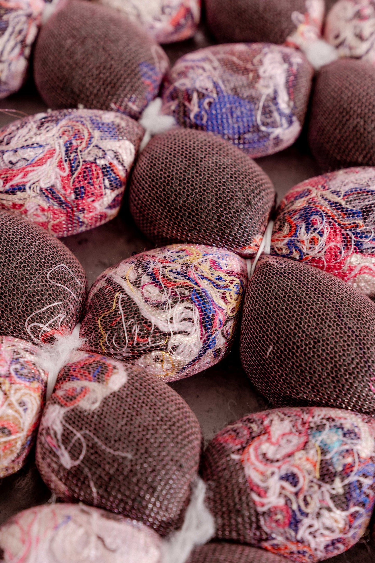 close-up of hand-knotted knit seat cushion with transparent cover filled with upcycled materials
