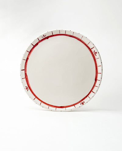 White festive platter with red decorative rim on a white background
