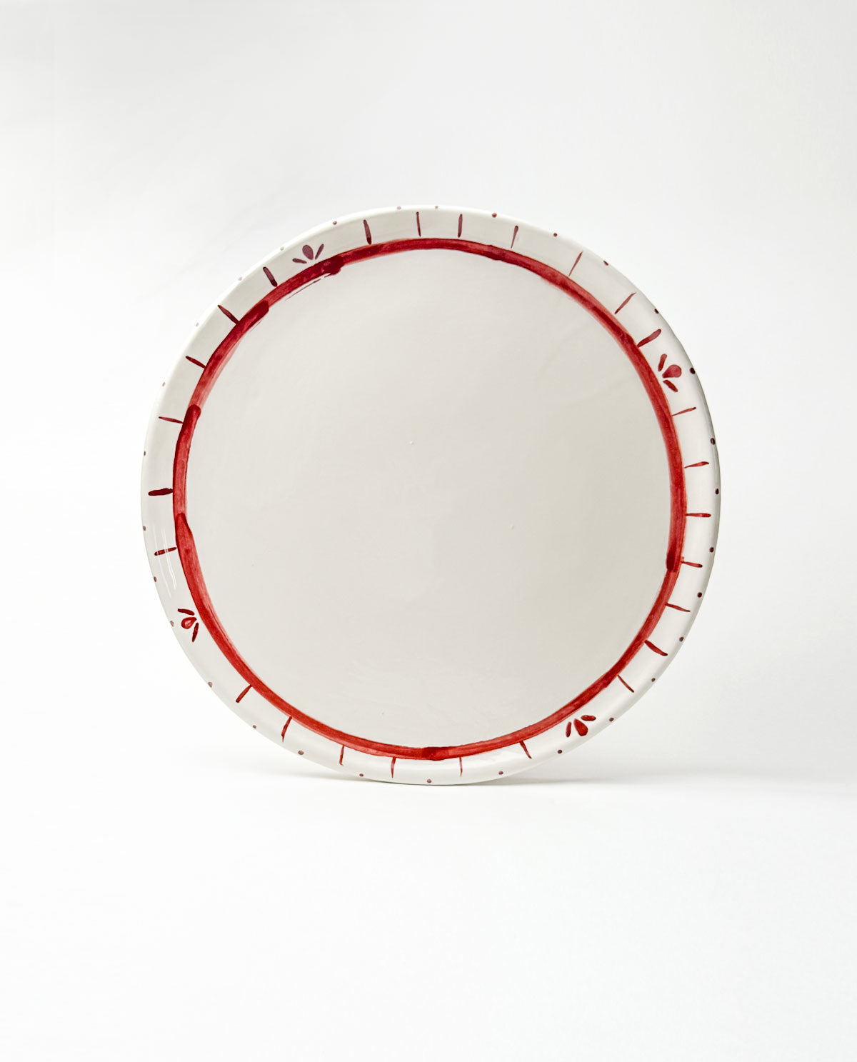 White festive platter with red decorative rim on a white background