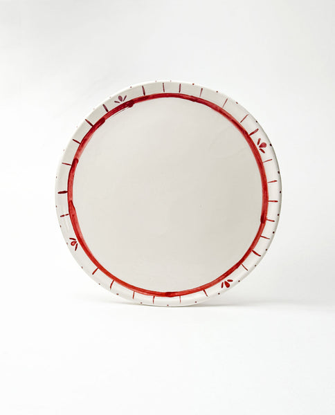 White festive platter with red decorative rim on a white background
