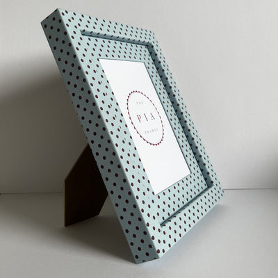 Angled view of handmade blue and burgundy Pembroke polka dot picture frame, showcasing the frame on a stand