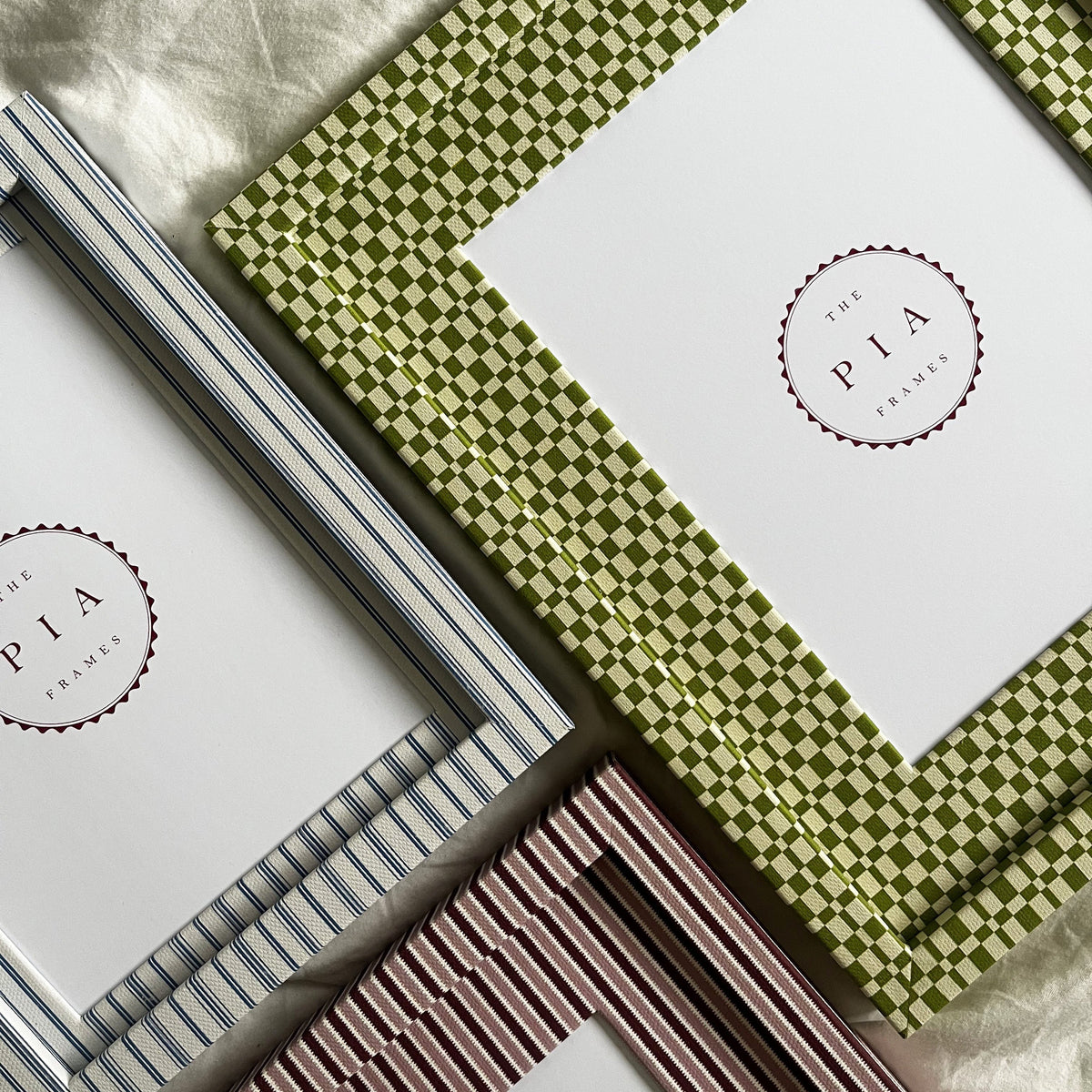 Set of three handmade colourful fabric picture frames on a white fabric background