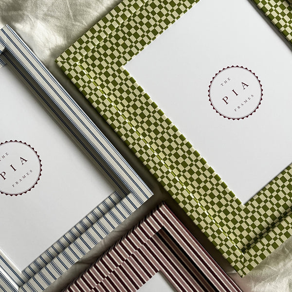 Set of three handmade colourful fabric picture frames on a white fabric background