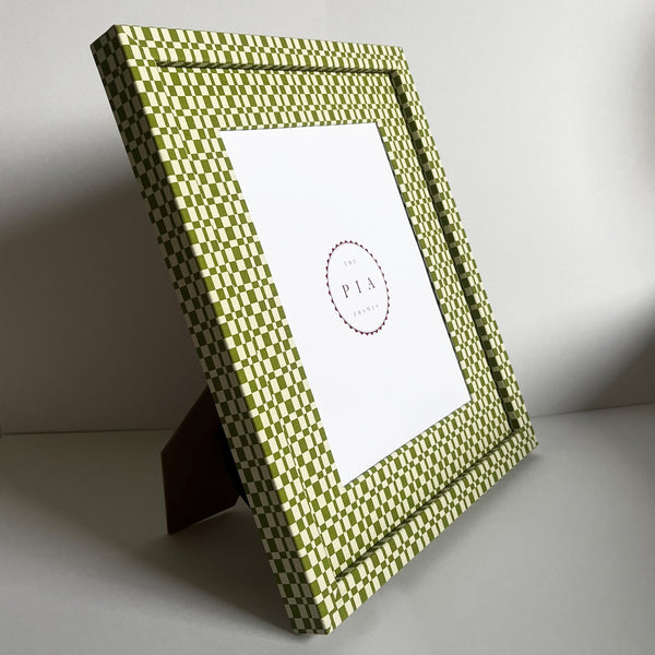 Handmade green and beige checkered picture frame standing on a stand, showcasing its design and depth