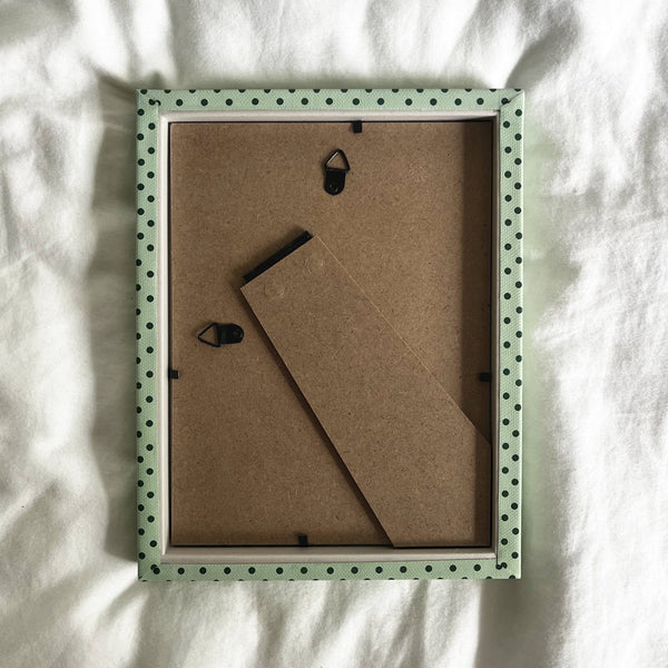 Back view of handmade mint green and jade Pembroke polka dot fabric picture frame, showing wall fittings and frame structure