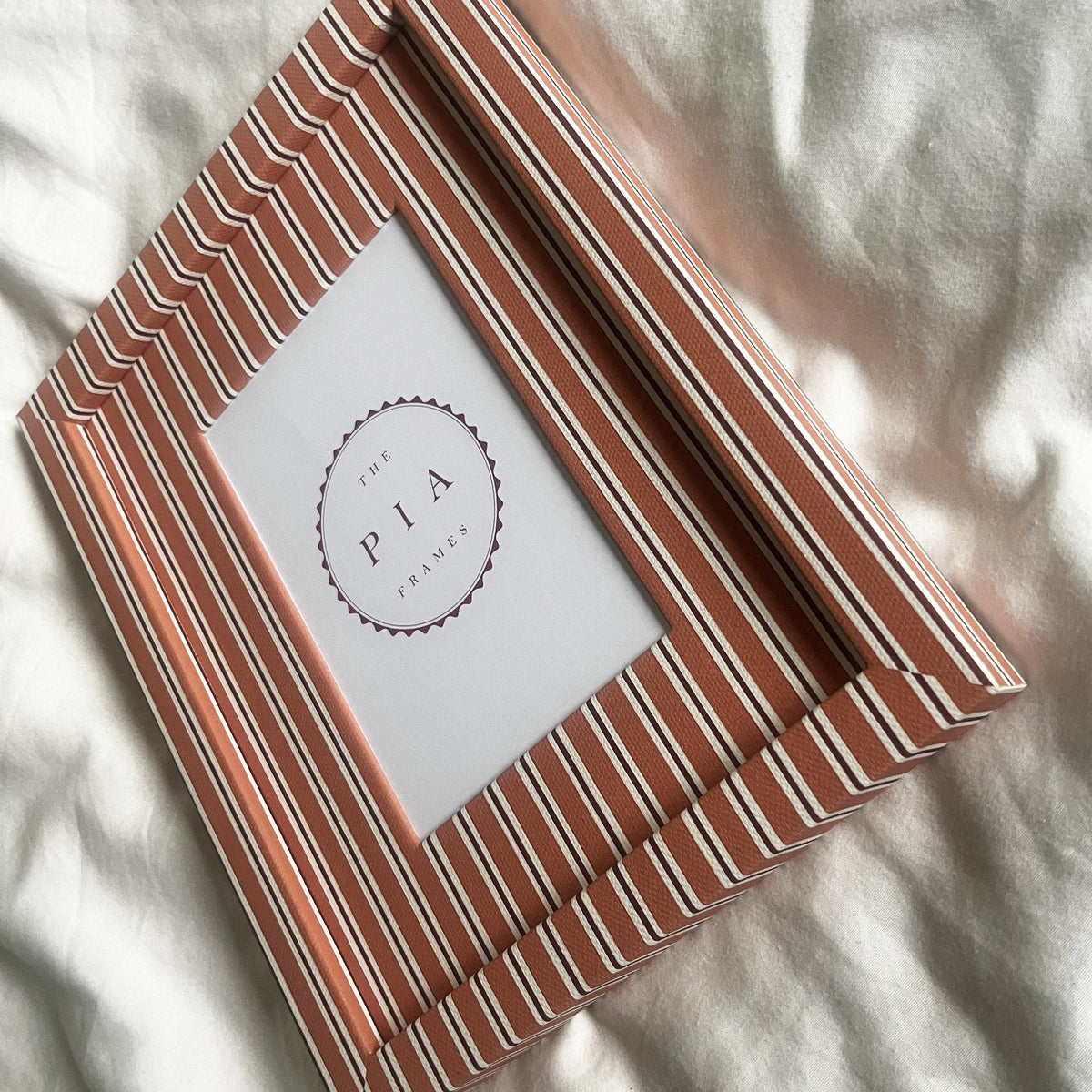 Side view of handmade orange and burgundy stripe picture frame, showcasing the frame’s depth and design