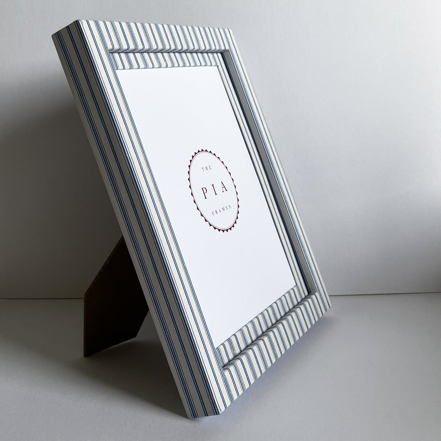 Rustic blue striped picture frame stood up on a stand, showcasing the frame’s design and depth