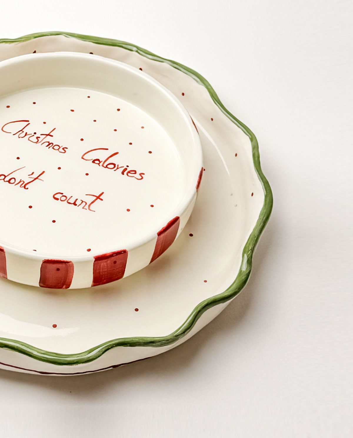Decorative ceramic plate with text 'Christmas Calories don't count' on a white background