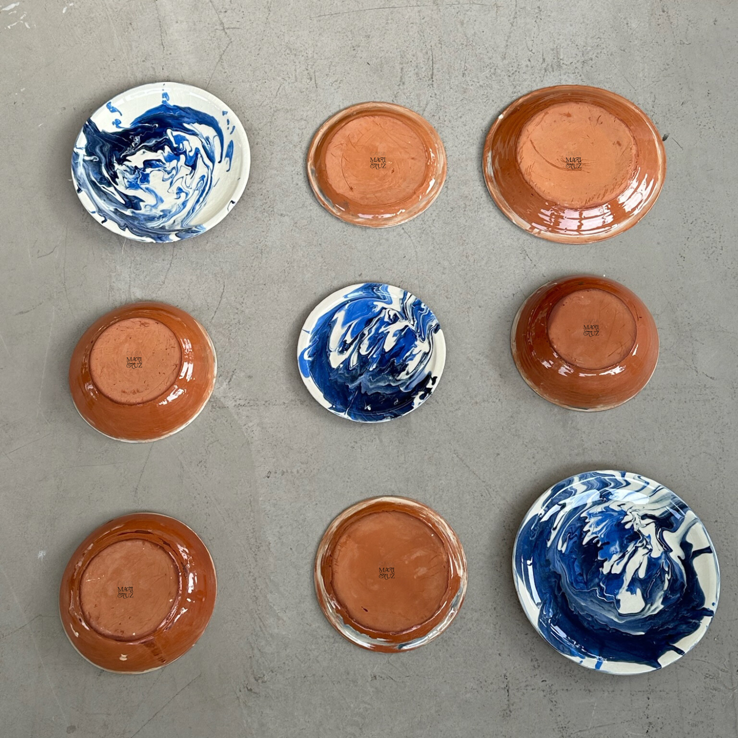 Set of ceramic plates with blue and white swirl patterns on a gray surface - lifestyle