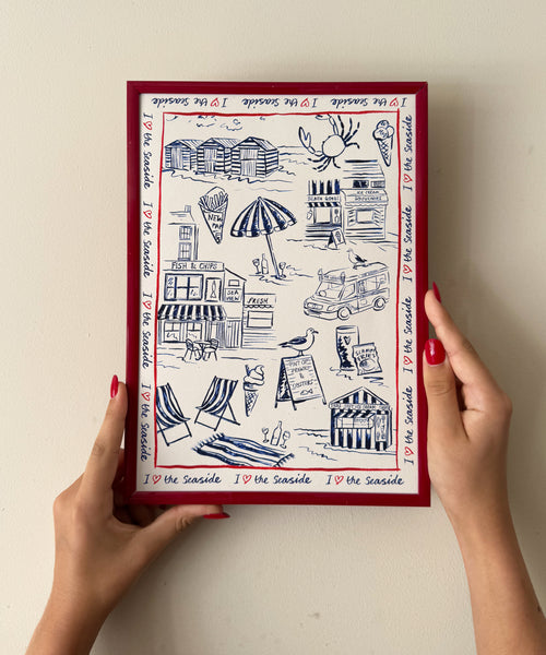 I Love The Seaside print, toile-style beach scene with ice cream van and seagulls being held up