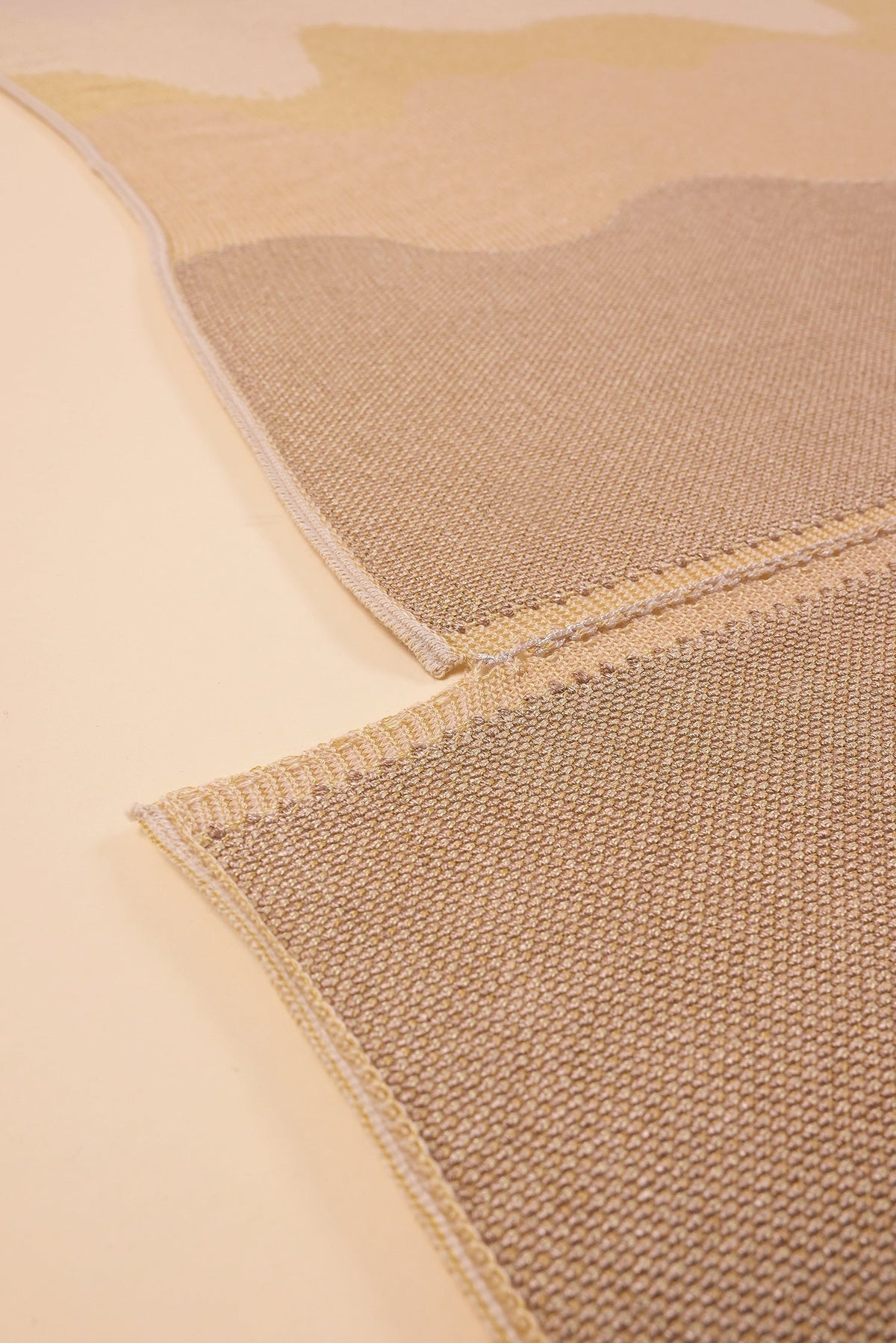 bottom detail of organic cotton knit tablecloth with hand-stitched seam in yellow monochrome tones