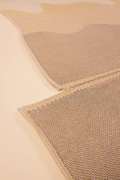 bottom detail of organic cotton knit tablecloth with hand-stitched seam in yellow monochrome tones
