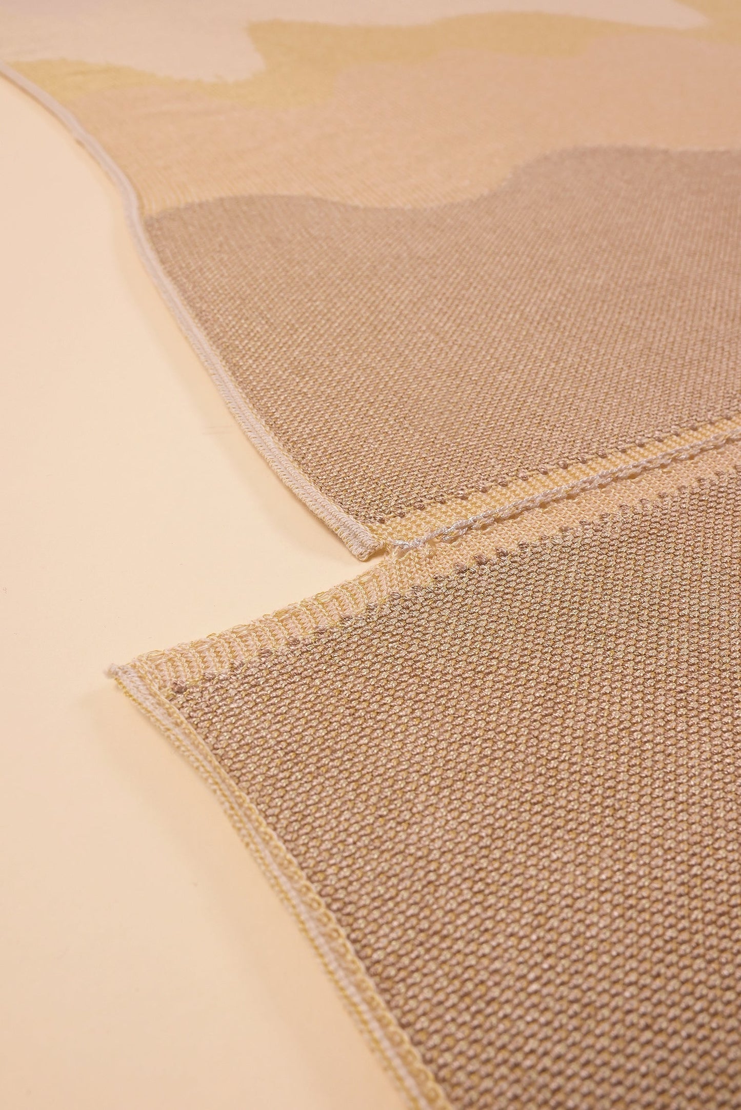 bottom detail of organic cotton knit tablecloth with hand-stitched seam in yellow monochrome tones
