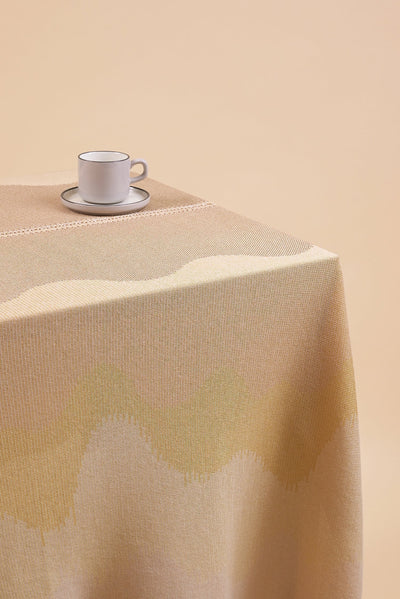 close-up of organic cotton knit tablecloth with hand-stitched seam in yellow monochrome tones