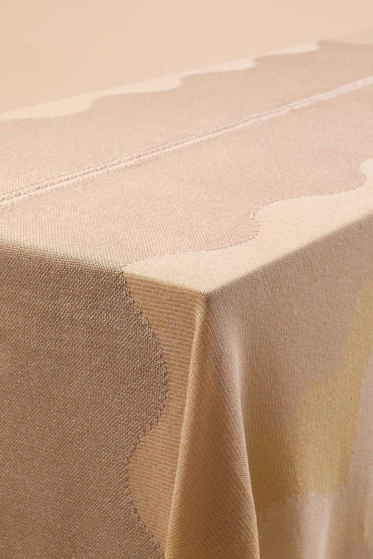 detail of organic cotton knit tablecloth with hand-stitched seam in yellow monochrome tones
