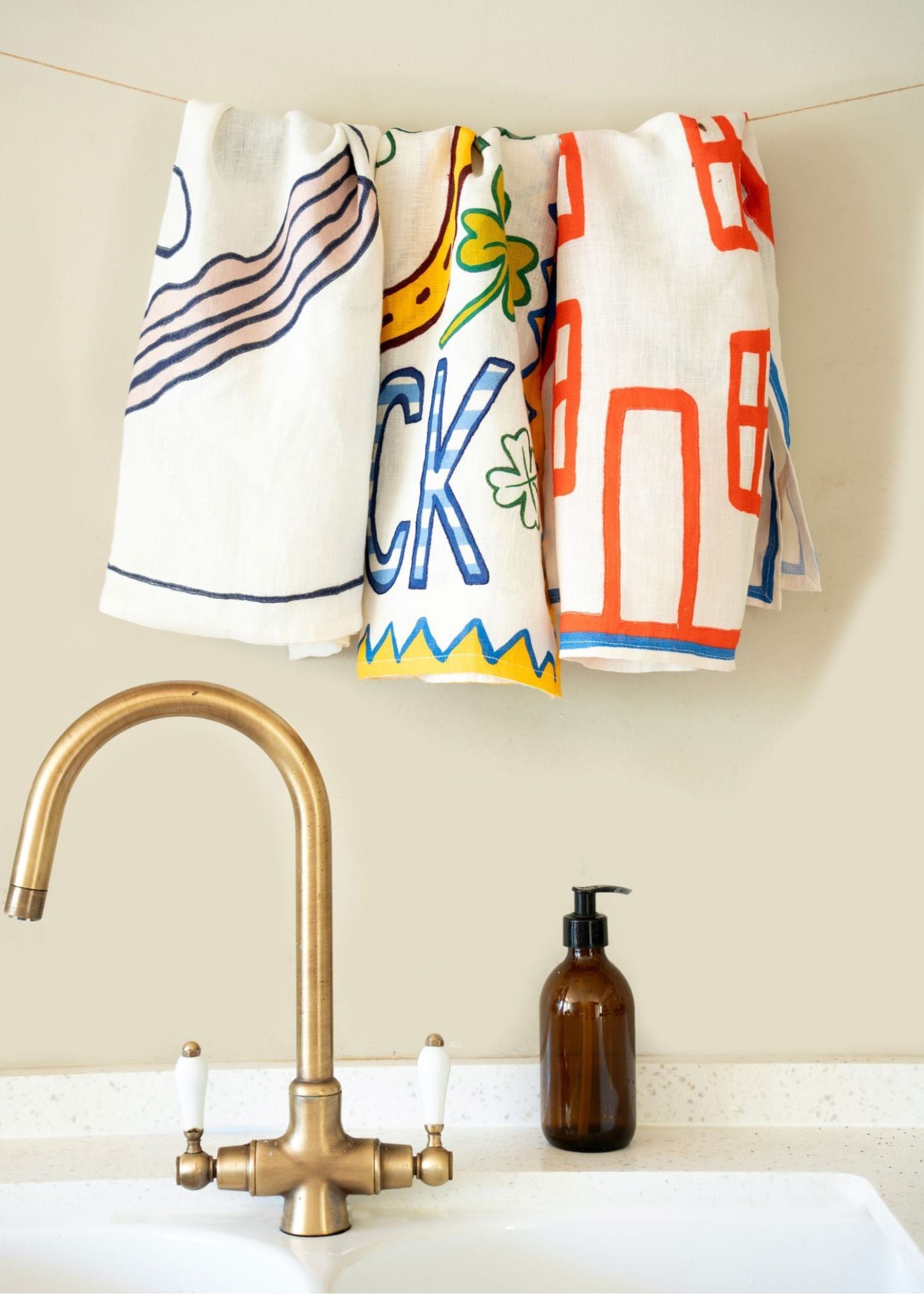 Set of 3 tea illustrated tea towels hanging above a kitchen sink