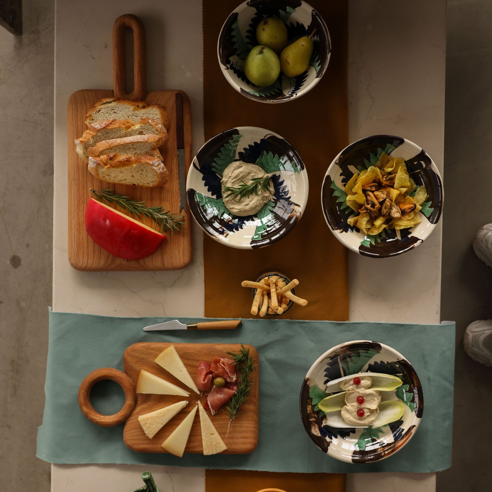 Top-down view of a dining table with various dishes and food items on a checkered tablecloth. - lifestyle