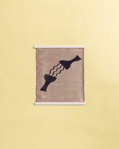 front view of pink knit wall hanging in with wooden magnetic frame on background
