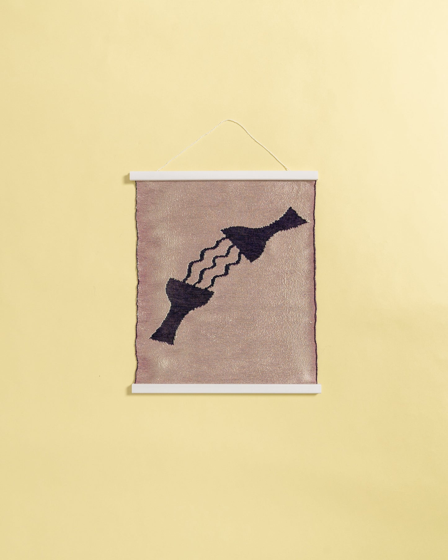 front view of pink knit wall hanging in with wooden magnetic frame on background
