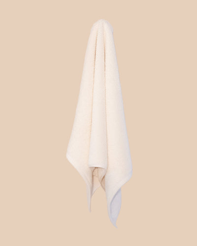 White hand  towel hanging against a beige background