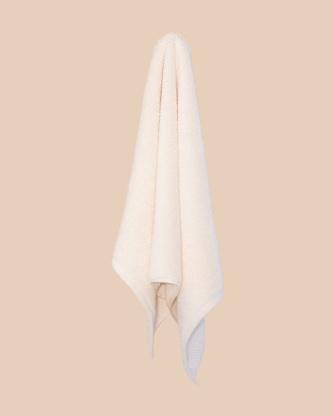 White hand  towel hanging against a beige background