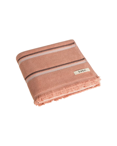 Folded Clay towel with black and cream stripes, raw edge fringing. Kobn logo. 
