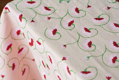 Light pink floral tablecloth styled on Italian-inspired tablescape