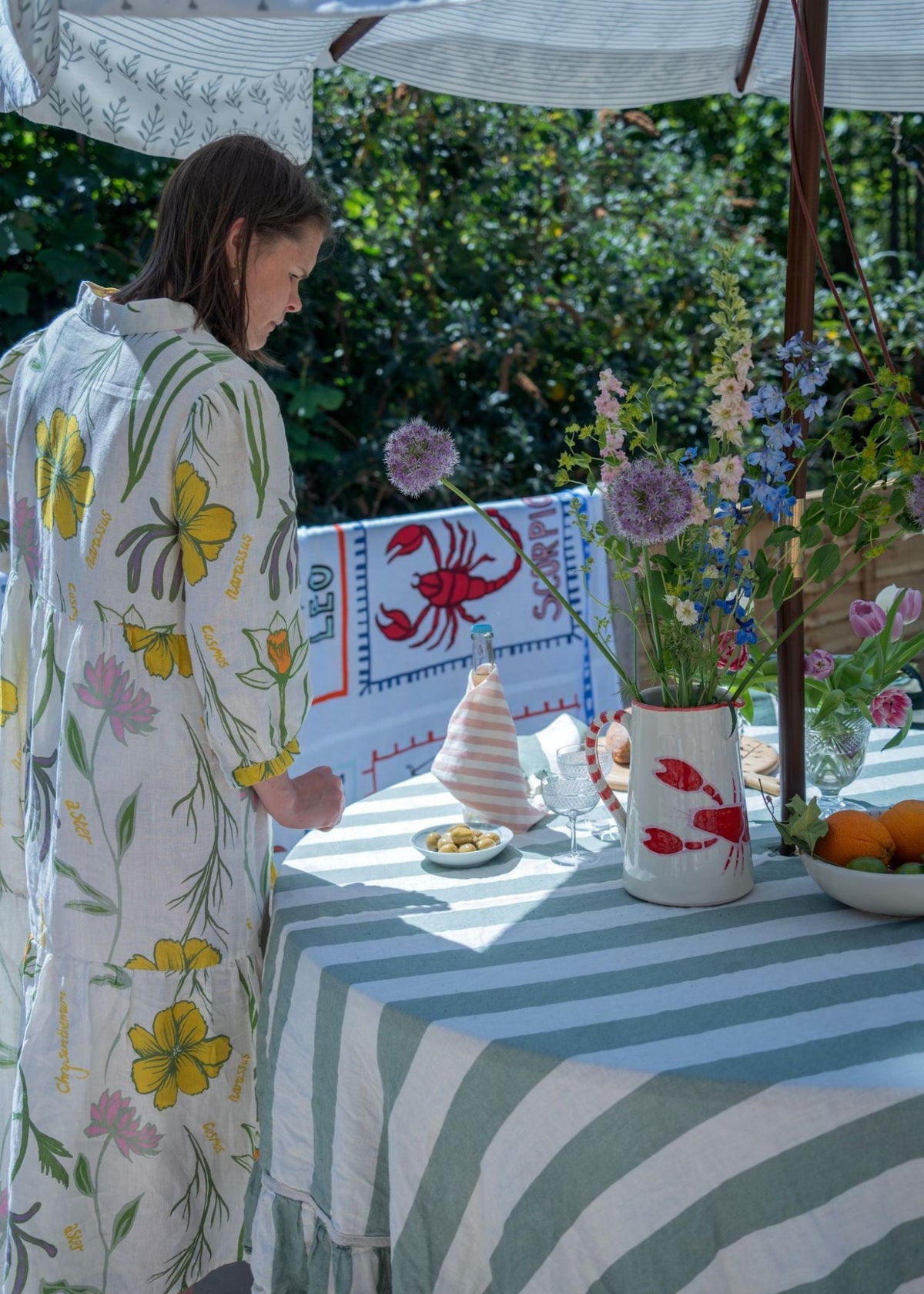 Lobster ceramic on set up lunch table. Table features, jug, napkins and food.