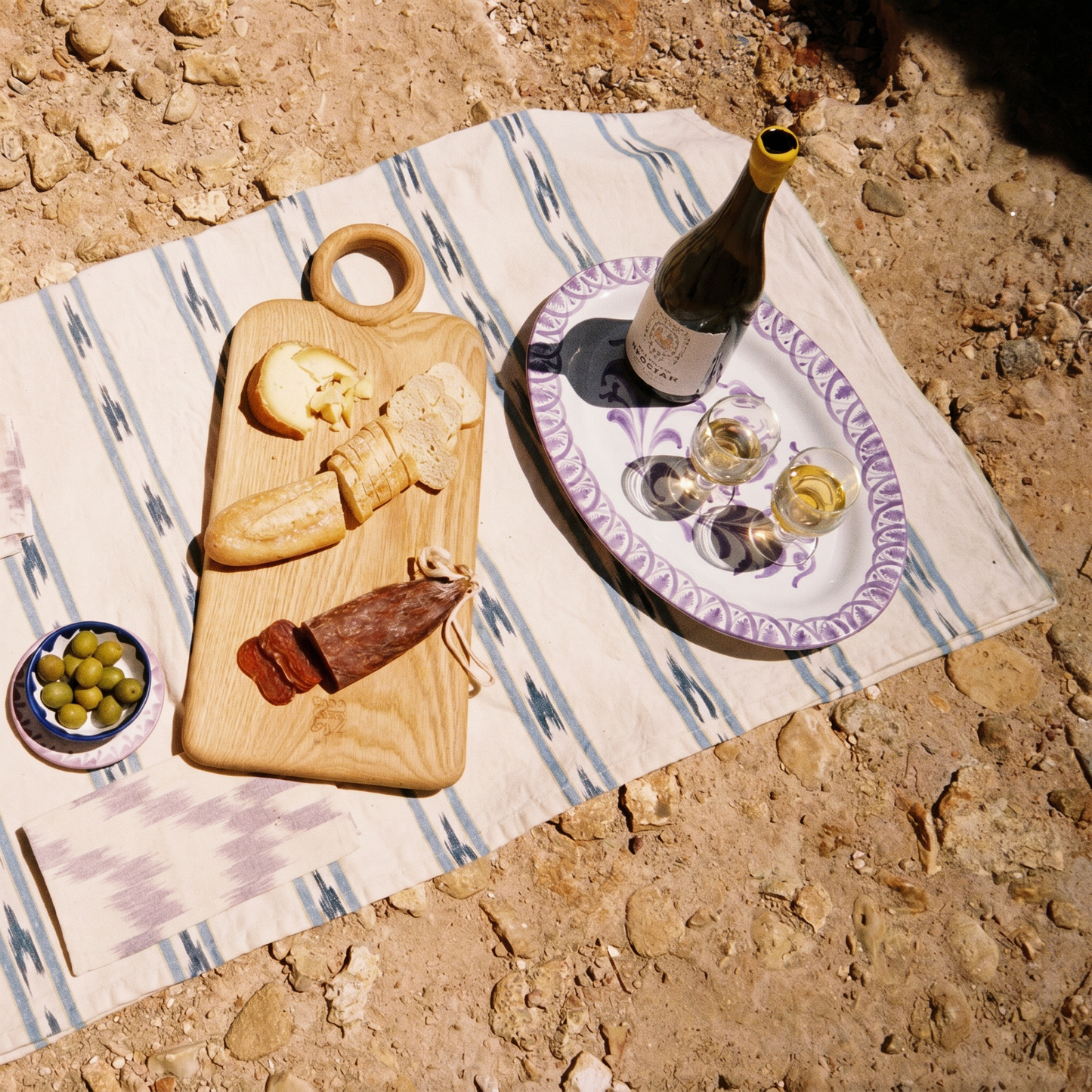 table set on the beach, wooden board and oval plate - lifestyle