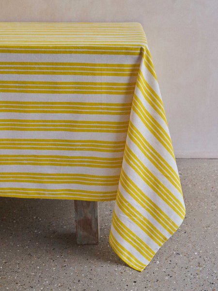 Yellow stripe tablecloth hanging over a table 