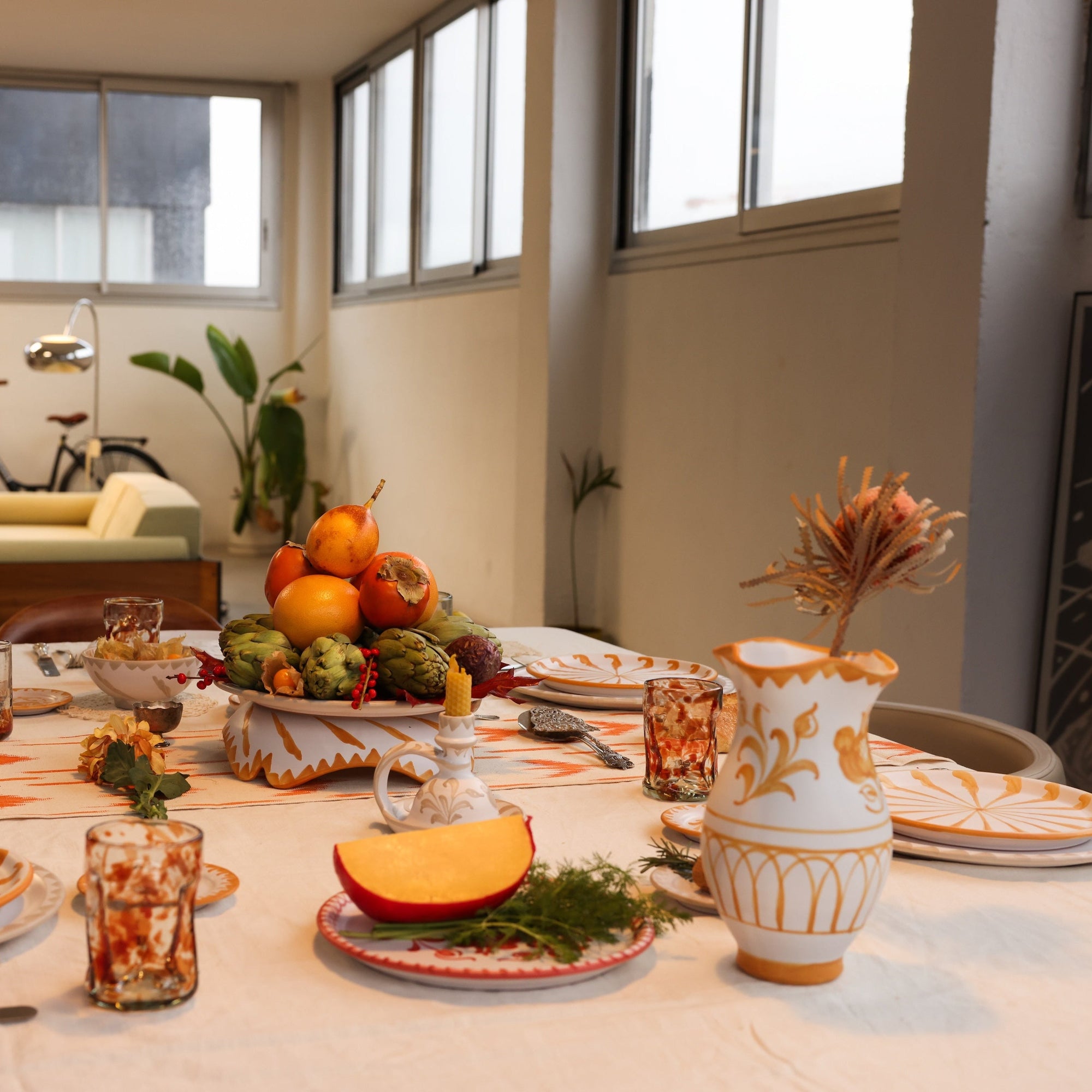 Dining table set with a thanksgiving theme in a room with a bicycle and plants. - lifestyle