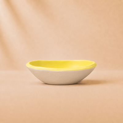 Yellow and white ceramic bowl on a beige background