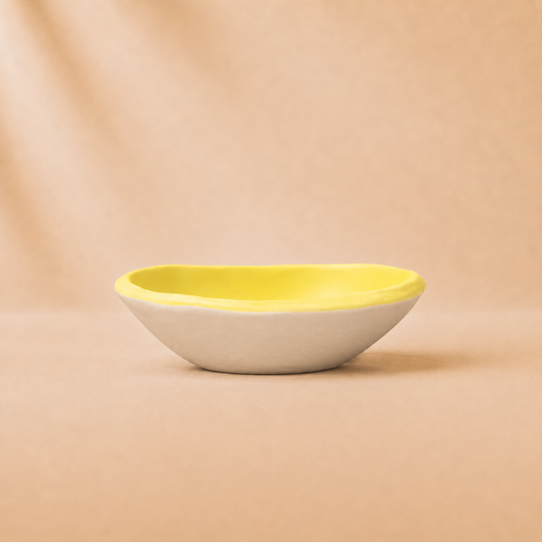 Yellow and white ceramic bowl on a beige background