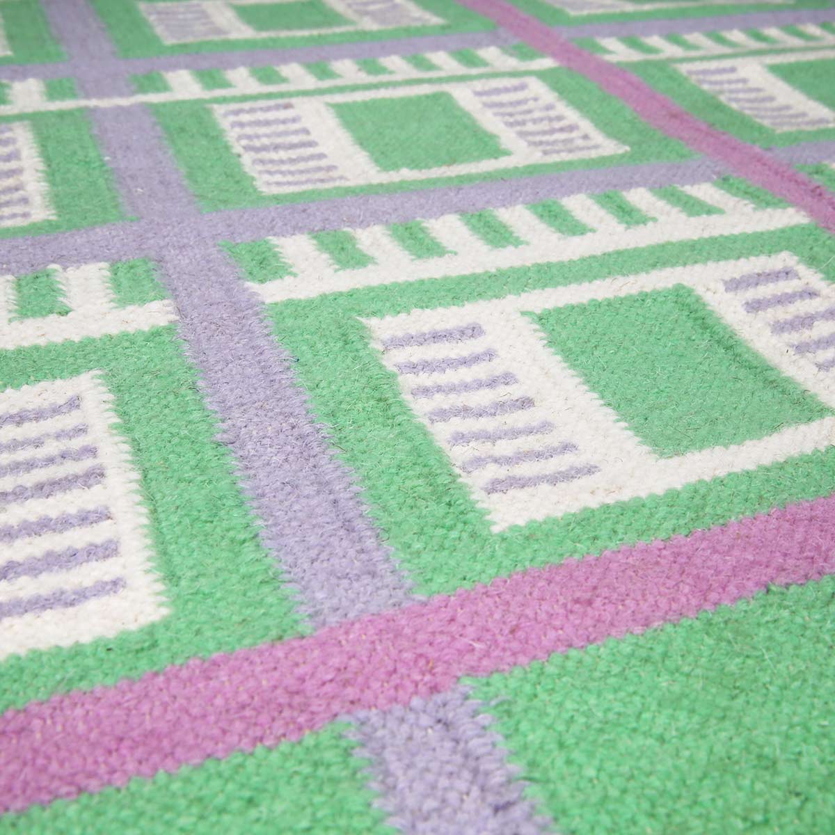 Detail of the Green Labourdonnais Rug handwoven with a checkered grid pattern.