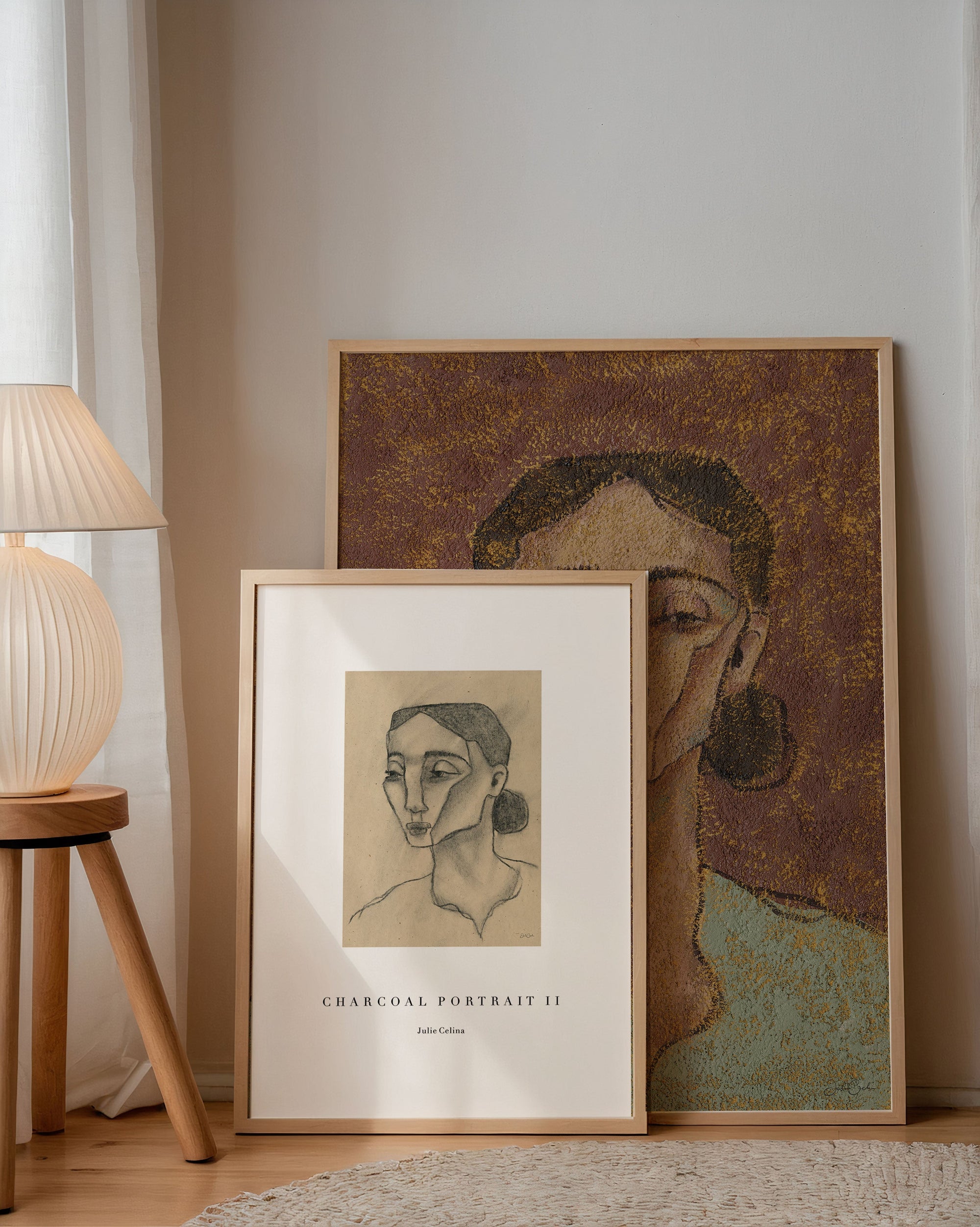 two art prints of portraits of women standing up against a white wall