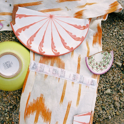 Broken ceramic pieces on a fabric with a pattern on a stone surface