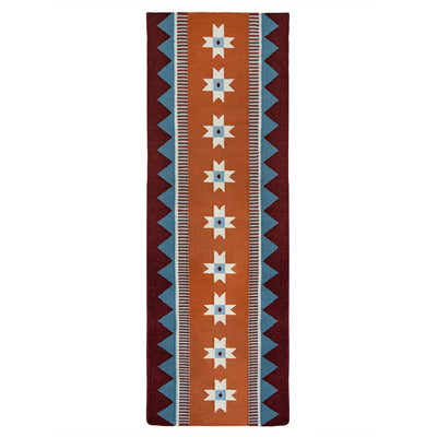 Orange runner rug handwoven from New Zealand wool with a geometric design of star motifs and a blue zig zag border inspired by Victorian tiles.