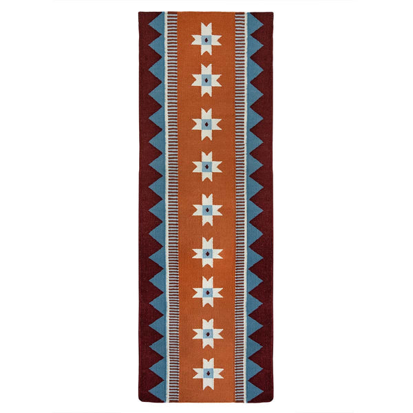 Orange runner rug handwoven from New Zealand wool with a geometric design of star motifs and a blue zig zag border inspired by Victorian tiles.