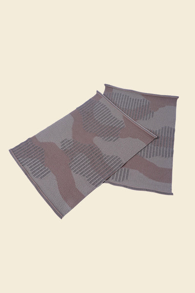 top side view of beige knit organic cotton table mat with abstract design in pair