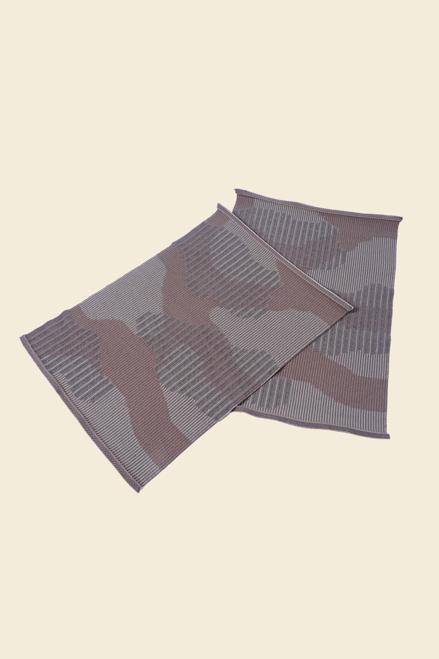 top side view of beige knit organic cotton table mat with abstract design in pair