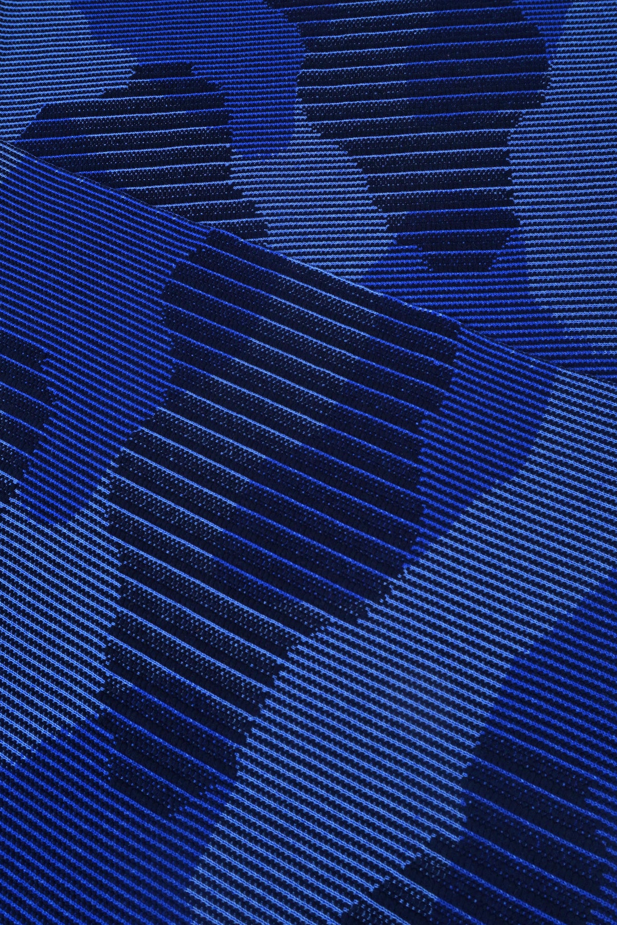 close-up of blue knit organic cotton table mat with abstract design