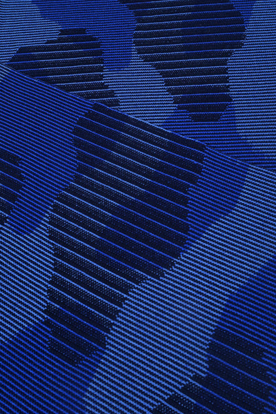 close-up of blue knit organic cotton table mat with abstract design