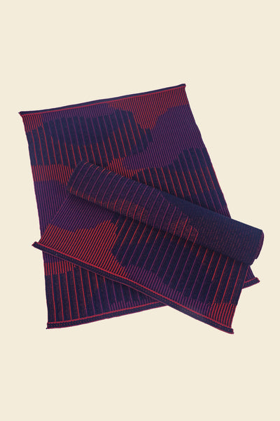 top view of red knit organic cotton table mat with abstract design in pair
